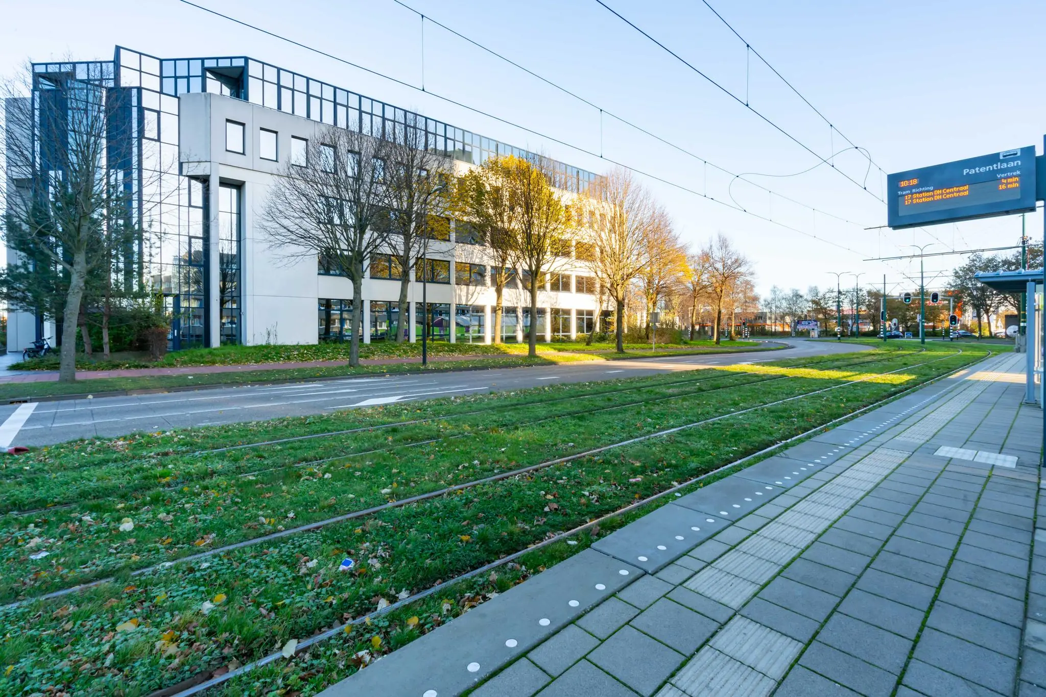 Tramhalte aan de De Bruyn Kopsstraat met modern kantoorgebouw op de achtergrond.
